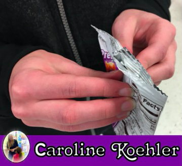Student opening a snack bag.