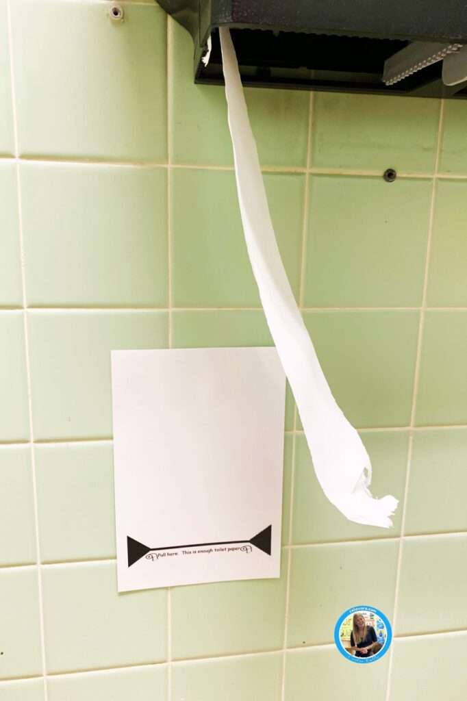 The picture showing toilet paper in a school, restroom and assign below the toilet paper that reads, "Pull here. This is enough toilet paper."
