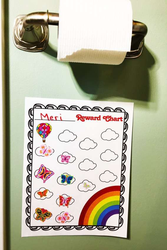 Potty training, rewards charts, showing a sticker chart with rainbows and balloons in a bathroom