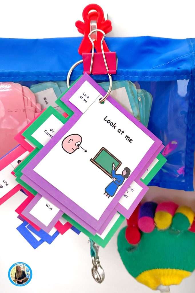 Non verbal cue cards for autism showing a card that says, "Look at me" on a classroom wipe off board.