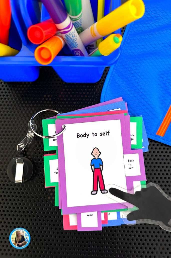 Visual cue cards for autism showing a body to self card in a classroom work area.
